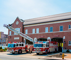 Two Fire Trucks Parked in Front of Bay Doors at the Franklin Street Fire Station