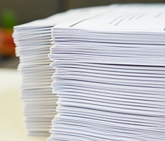 Stack of White Paper Printouts on a Table
