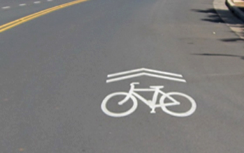 Road with Marking of Bicycle and Two Chevrons Painted in White
