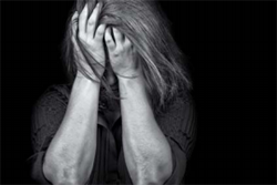 Black and White Photo of Woman Crying Into Hands
