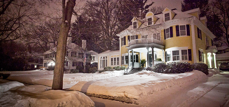 Snow Covered Yellow Victorian Home and Yard