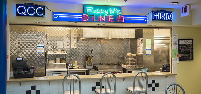 Restaurant Counter for Bobby M's Diner with Stools in Front and Neon Lighted Signs Above the Window