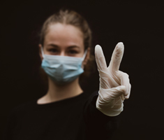 Girl Wearing Mask Holding Up Peace Sign