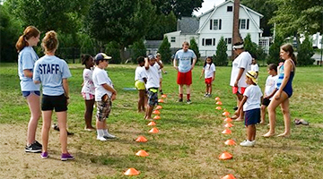 Children and Counselors Playing a Game with Cones Outside