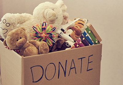 Box with Word Donate Written on Side, Filled with Toys and Stuffed Animals