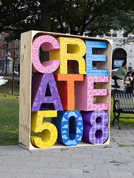 Art Installation of Wooden Crate with Colorful Cardboard Letters Spelling Create 508