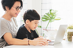 Parent and Child Sitting at Laptop