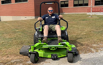 Staff Using Green Electric Lawn Mower