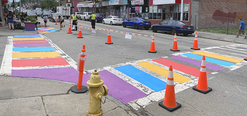 Part of Main Street Blocked Off with Cones with Volunteers Painting Colorful Crosswalks with Paint