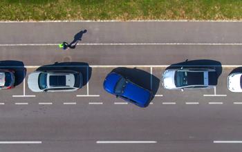 Aerial View of Car Parallel Parking on Street with Protected Bike Lane to its Right