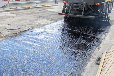 Large Truck Spraying New Asphalt on Road