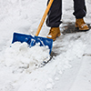 Blue Shovel Removing Small Pile of Snow on a Sidewalk