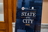 Blue and Black State of the City Sign on Tripod Near Door