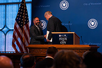 City Manager Batista Shaking Hands with Mayor Petty at Podium