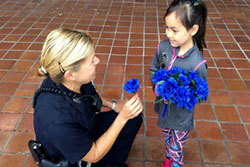 Police Officer Handing Flowers to Child
