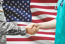 Solder and Doctor Shaking Hands in Front of Flag