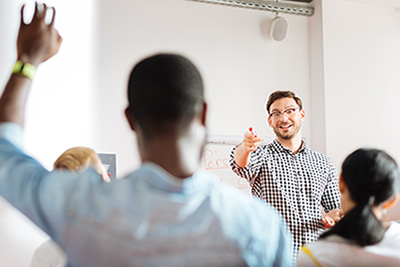 Group of Employees in a Training Session with Man Raising His Hand