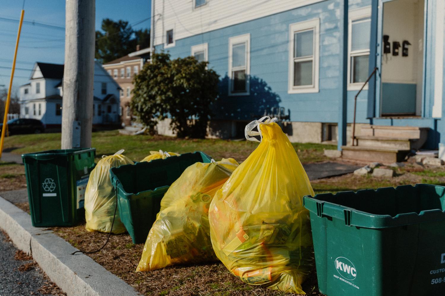 Photo of yellow trash bags and recycling bins