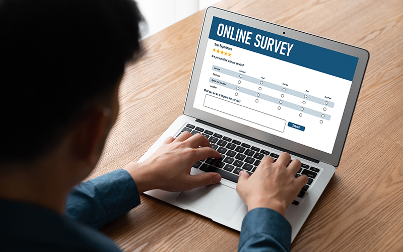 Person Working on Laptop that has Online Survey on Screen