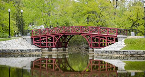 Red Bridge at Elm Park with Green Trees in Background