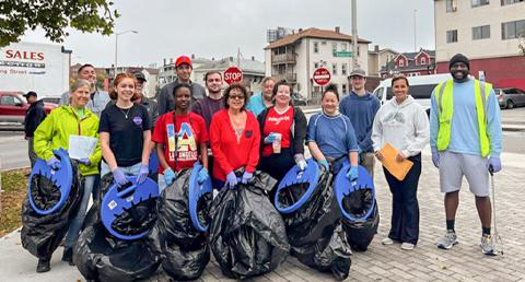 Large Group of Volunteers on Sidewalk Holding Black Trash Bags and Work Gloves