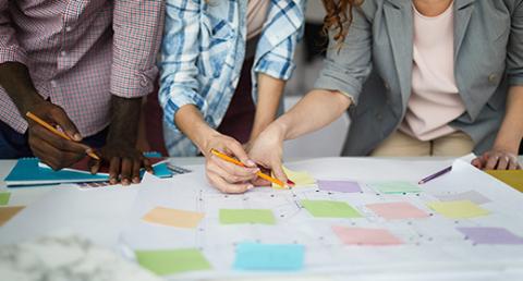 People Gathered Around a Table with Papers and Charts