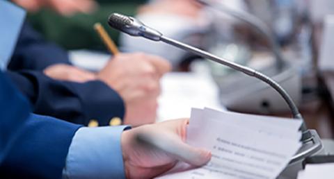 Man's Hand Holding a Speech at a Podium